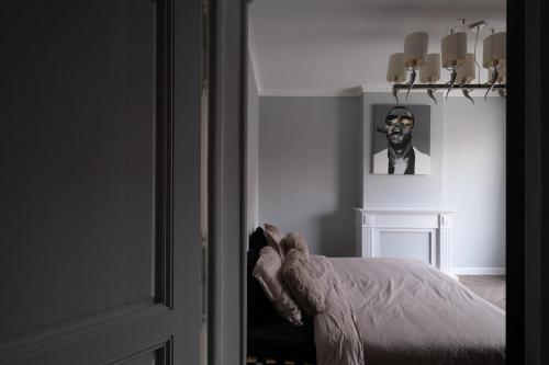 a room with a bed and a picture of a man at Luxe city villa te Hasselt in Hasselt