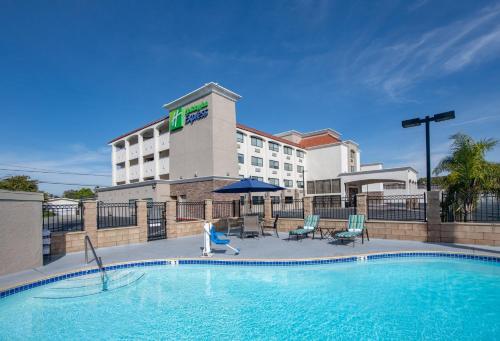 a hotel with a swimming pool in front of a building at Holiday Inn Express San Diego South - National City by IHG in National City