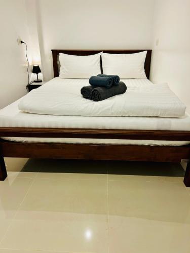 a bed with white sheets and a blue bag on it at Island House Rentals 46 in Ko Samed