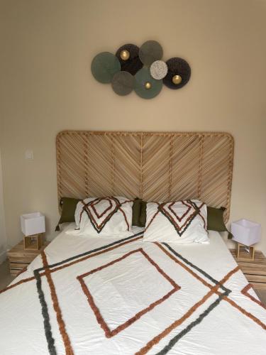 un lit avec une tête de lit en bois et 2 réveils sur le mur dans l'établissement Bastidon et son patio à Saint Rémy de Provence, à Saint-Rémy-de-Provence