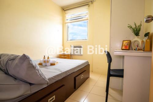 una piccola camera da letto con un letto e una scrivania di Balai Bibi at Urban Deca Homes Ortigas 3Br a Manila