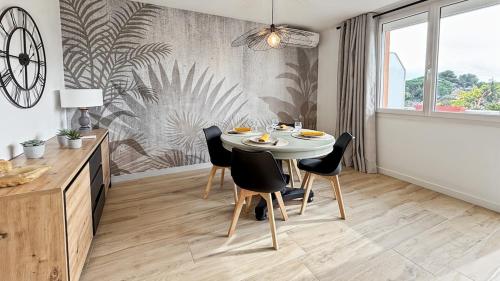 une salle à manger avec une table et des chaises blanches dans l'établissement Appartement a quelques minutes à pieds des plages, à Fréjus