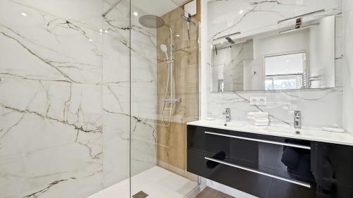 a bathroom with a shower and a sink and a mirror at Appartement a quelques minutes à pieds des plages in Fréjus