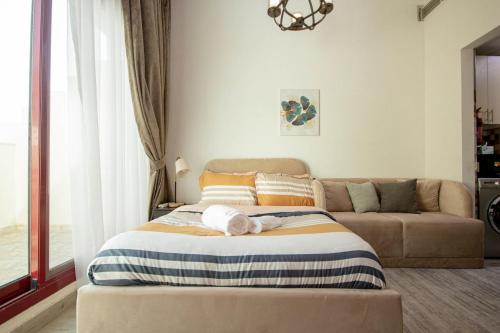 a bedroom with a bed and a couch at Cozy Studio for Daily Rental Warsan in Dubai