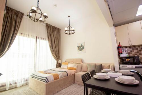 a living room with a couch and a table at Cozy Studio for Daily Rental Warsan in Dubai