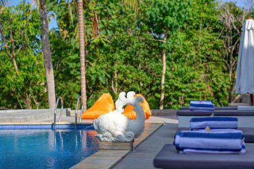 a pool with a statue of a chicken next to a swimming pool at Kelingking Beach Villas in Nusa Penida