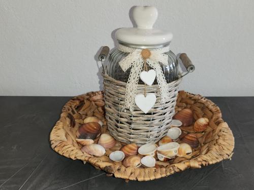 a basket of shells and a vase on a table at Casa MedeFaby in S'archittu Cuglieri