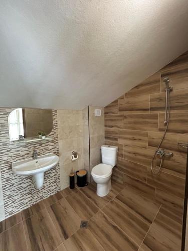 un baño con inodoro y lavabo en Вилно селище Зора, en Shkorpilovtsi