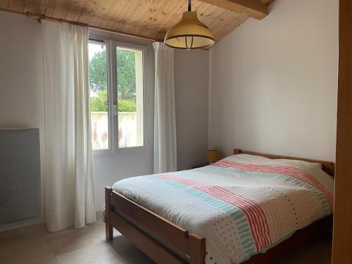 une chambre avec un lit et une fenêtre dans l'établissement ღ L'Epinette - Proche Plage, Wi-Fi & Parking, à La Couarde-sur-Mer