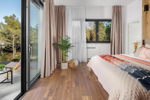 a bedroom with a bed and a large window at Villa Luxor in Zambratija