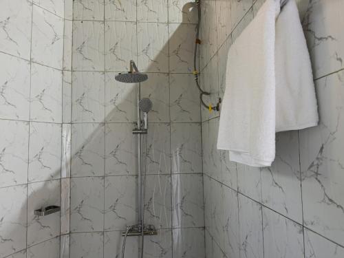 a bathroom with a shower with a white towel at Mountain Inn Resort in Buikwe
