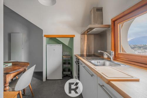 une cuisine avec un évier et une fenêtre dans l'établissement R'Apparts T2 La Halte Savoyarde, à Aix-les-Bains