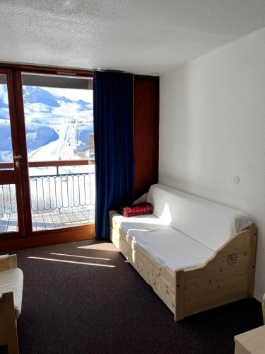 une chambre avec un lit et une grande fenêtre dans l'établissement Appartement Arcs 2000, à Bourg-Saint-Maurice