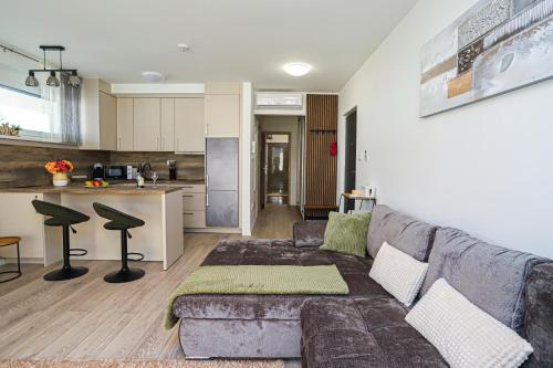 a living room with a couch and a kitchen at Hullám Seaside Balatonlelle, Ajándék SUP használattal!! Free SUP in Balatonlelle