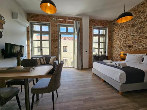 a bedroom with a bed and a table and a couch at Silk Suites by YHA in Athens