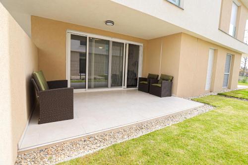 a patio of a house with two chairs at Hullám Seaside Balatonlelle, Ajándék SUP használattal!! Free SUP in Balatonlelle