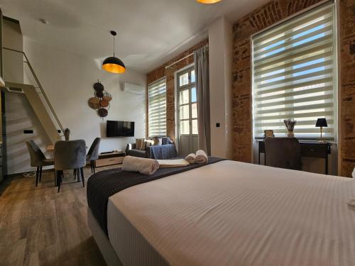a bedroom with a large white bed and a desk at Silk Suites by YHA in Athens