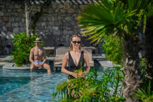 a woman standing in the pool at a resort at Ramitos Hotel in Turunc
