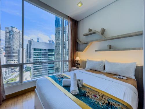 a bedroom with a large bed with a large window at Vortex Suites Klcc By VIP SUITES in Kuala Lumpur