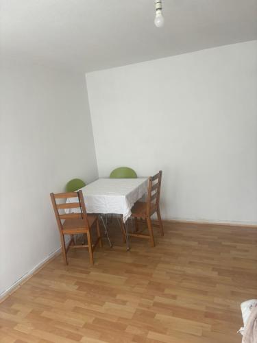 a table and chairs in a room with white walls at Cavendish house in Strawberry Hill