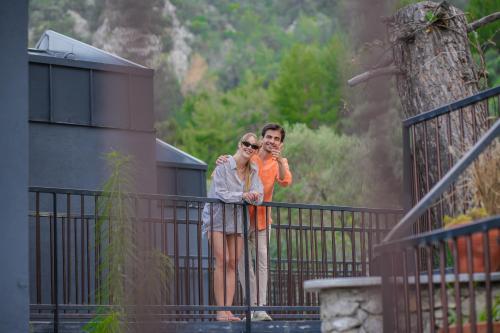 two people standing on a fence talking on their cell phones at Ramitos Hotel in Turunc