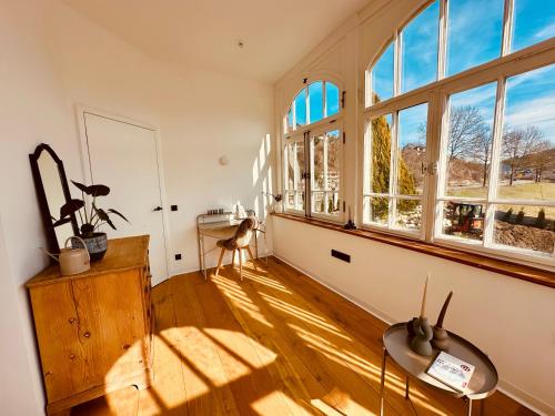 a living room with a large window and a table at luxuriöse Altbau Wohnung in Denkmal-Villa in Aidlingen