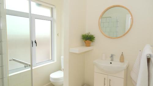 a bathroom with a toilet and a sink and a mirror at Saints Rest in Clarens