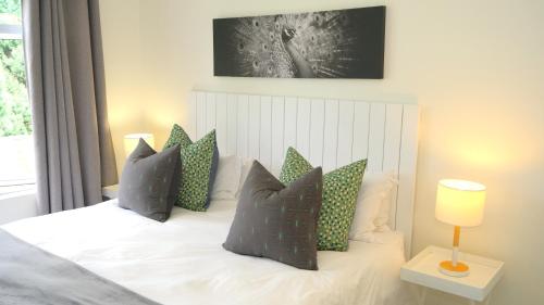 a bedroom with a bed with green and white pillows at Saints Rest in Clarens