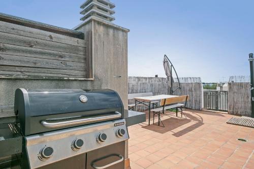 a grill and a picnic table on a patio at Apartamento Cubelles Molí Baix in Cubelles