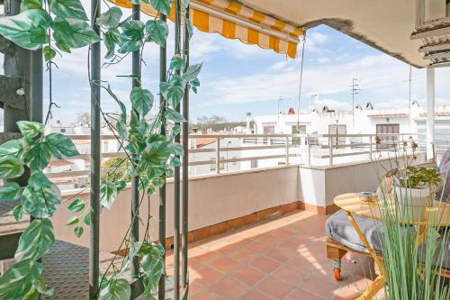 a balcony with a table and plants on a roof at Apartamento Cubelles Molí Baix in Cubelles