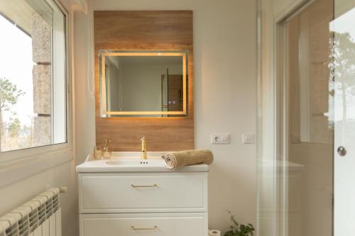 a bathroom with a sink and a mirror at Casa Fenix - Homey Galicia in Mos