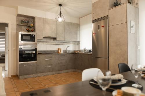 a kitchen with a stainless steel refrigerator and a table at Casa Fenix - Homey Galicia in Mos