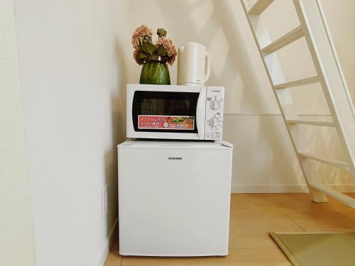 a microwave sitting on top of a refrigerator at Shin-Koenji loft apartment close to Tokyo Metro14mins to Shinjuku in Tokyo