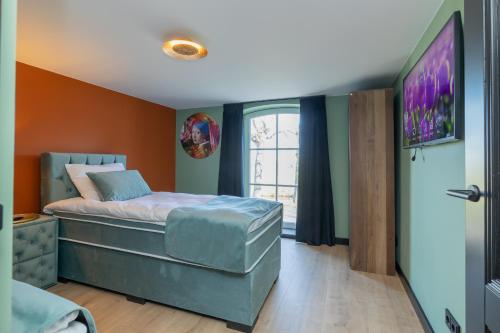 a bedroom with a bed and a flat screen tv at Villa Meer en Duin in Noordwijkerhout