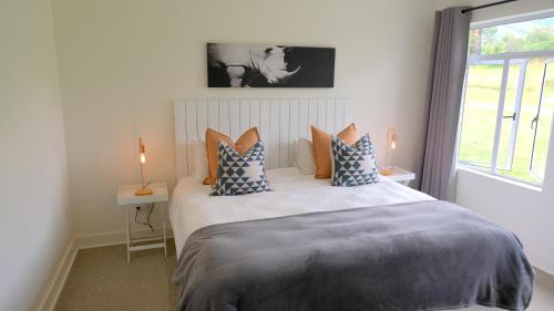 a bedroom with a bed with pillows and a window at Saints Rest in Clarens