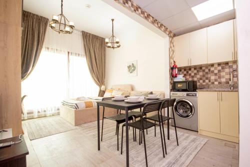 a kitchen and living room with a table and chairs at Cozy Studio for Daily Rental Warsan in Dubai
