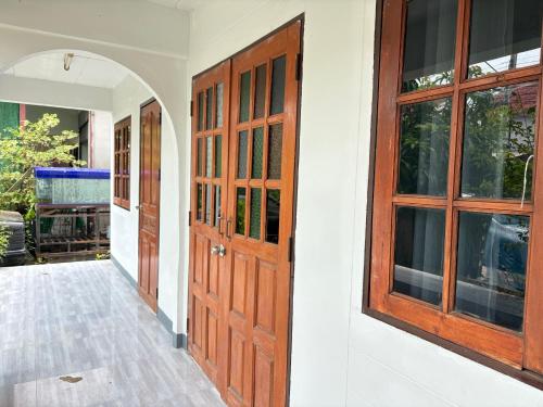 an entrance to a house with a wooden door at MeeboonHome in San Kamphaeng