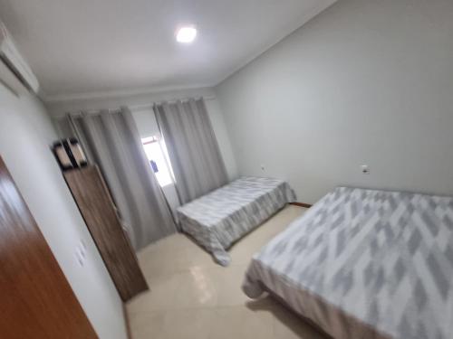 a small bedroom with two beds and a window at Casa na praia de Guriri Norte in São Mateus