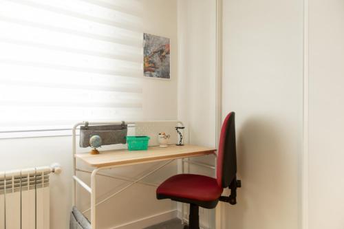 a desk with a red chair next to a window at Casa Fenix - Homey Galicia in Mos