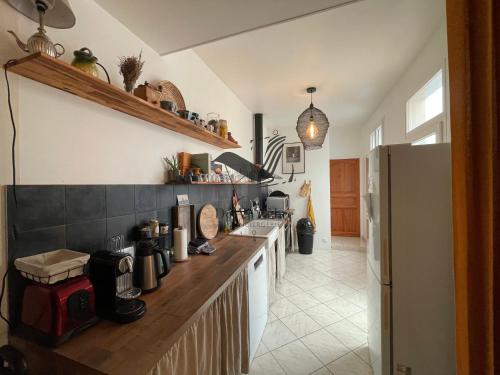 Il comprend une cuisine équipée d'un comptoir et d'un réfrigérateur. dans l'établissement Cocon Bleu - Maison idéalement située avec jardin, à Rochefort