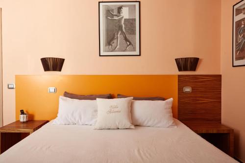 a bedroom with a bed with an orange wall at Villa Solaria in Massa Lubrense