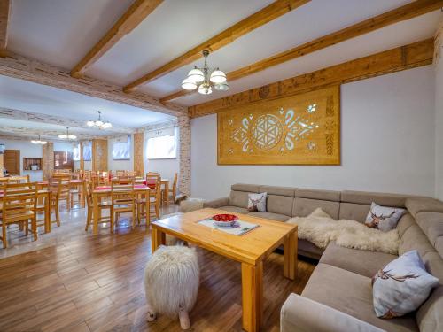 a living room with a couch and a table at Willa Pod Reglami - Małe Ciche - Sauna & Jacuzzi - 400m od Stacji Narciarskiej in Male Ciche