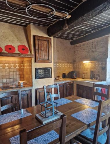 une cuisine avec une table en bois avec des chaises et un comptoir dans l'établissement Old Provencal house - 3 bedrooms, à Bagnols-en-Forêt