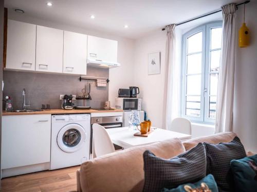 une cuisine et un salon avec une machine à laver dans l'établissement Les Ateliers de Philadelphe, à Gaillac