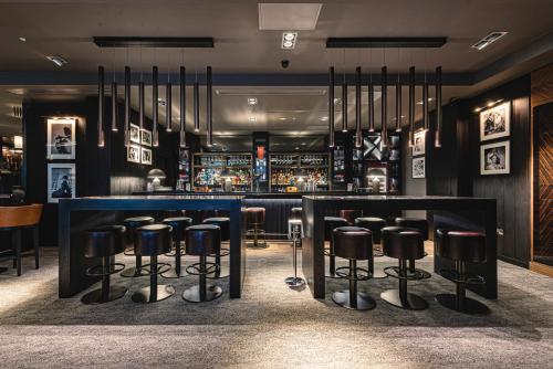a bar with black stools in a restaurant at Dakota Newcastle in Newcastle upon Tyne