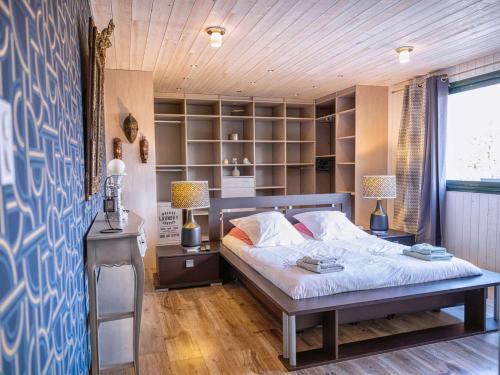 a bedroom with a bed and a desk with two lamps at Villa Magarre Climatisée, Piscine Chauffée, Spa, dans un Cadre Naturel Envoûtant in Castelnau-de-Montmiral