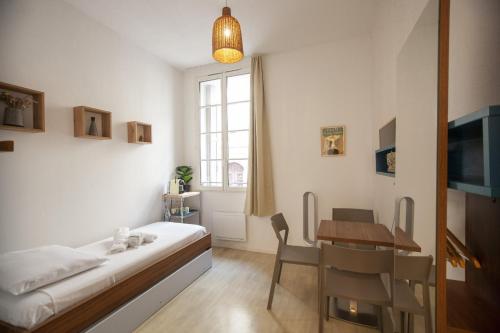 une chambre avec un lit et une table et une salle à manger dans l'établissement SENAC - Havre citadin, La Canebière, à Marseille