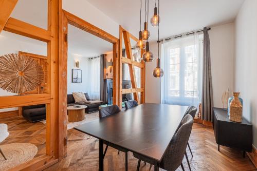 une salle à manger avec une table et un salon dans l'établissement L'Écrin Strasbourgeois - T3 avec grande terrasse, à Strasbourg