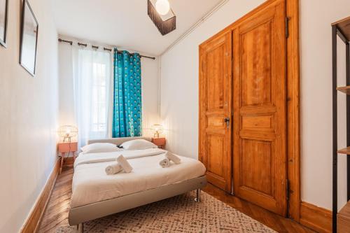 - une chambre avec un lit et une grande porte en bois dans l'établissement L'Écrin Strasbourgeois - T3 avec grande terrasse, à Strasbourg