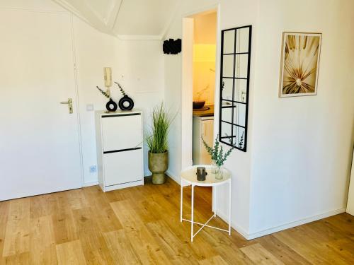 a white room with a table and a mirror at Gemütliches Loft in Homburg - Komfort & Charme direkt an der Uniklinik mit Küche und Bad in Homburg